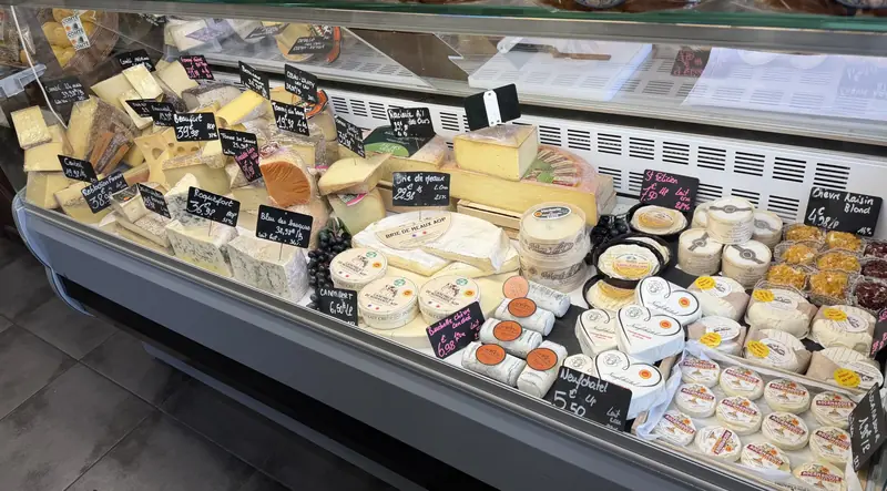 Le comptoir fromages : comté, beaufort, roquefort, brie de Meaux, camembert de Normandie, neufchâtel en cœur, rocamadour et chèvres, chacun avec son ardoise
