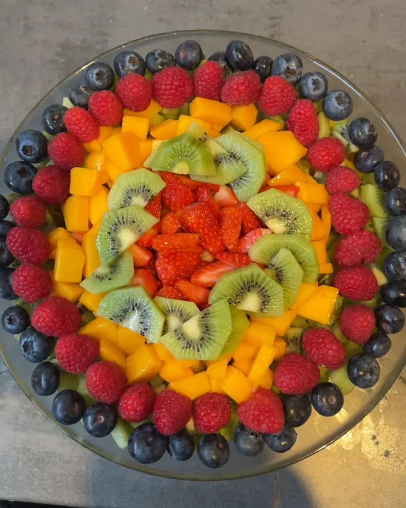 Salade de fruits maison : fraises, kiwis, mangue, framboises et myrtilles disposées en cercles